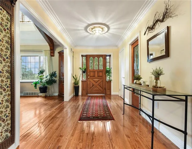 a view of a hallway with wooden floor and furniture
