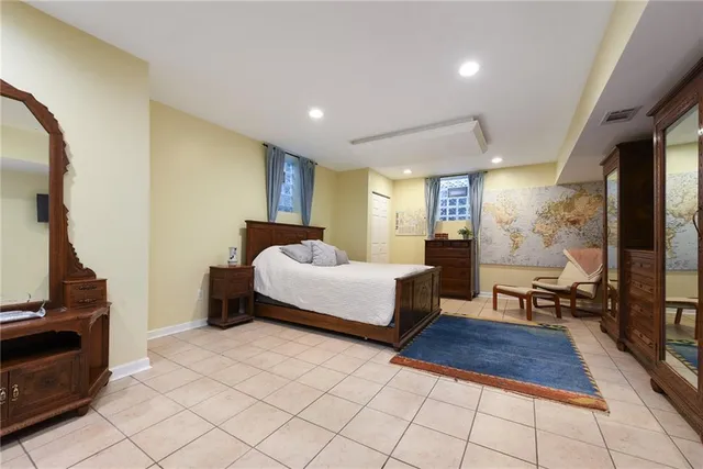 a spacious bedroom with a bed and wooden floor