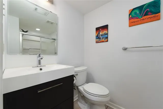 a bathroom with a sink mirror vanity and toilet