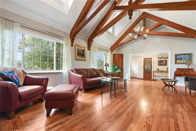 a living room with furniture a wooden floor and a large window