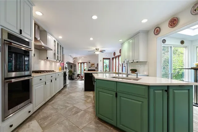 a kitchen with stainless steel appliances kitchen island granite countertop a sink and cabinets