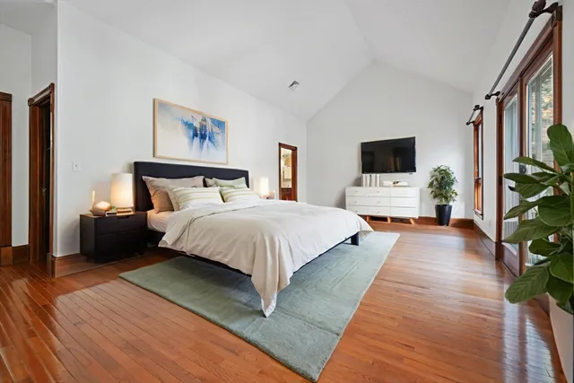 a spacious bedroom with a bed and a flat screen tv