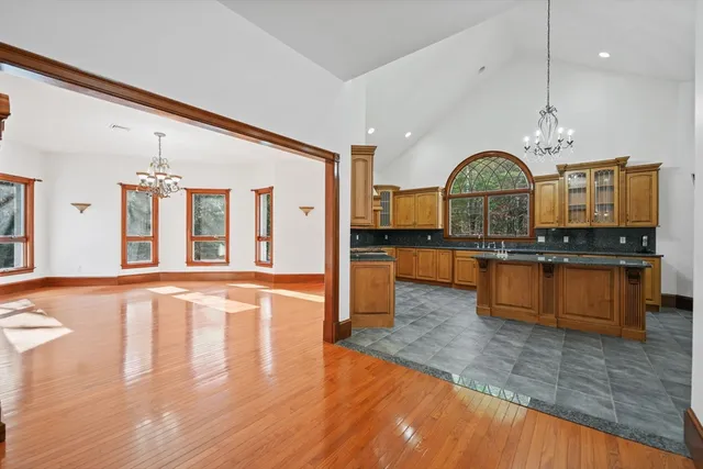 a large kitchen with stainless steel appliances granite countertop a stove and a wooden floors