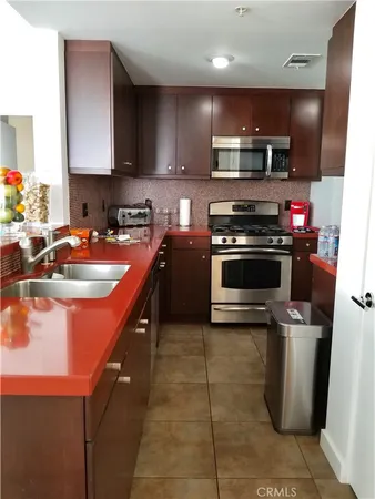 a kitchen with stainless steel appliances granite countertop a sink a stove and a microwave