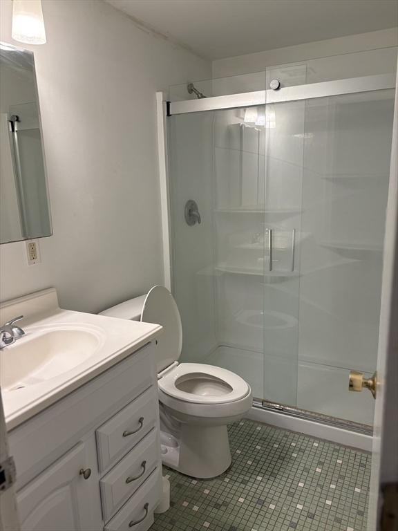 24 Spencer Road, Unit 12N Boxborough, MA 01719 - Photo 12 of 12 a bathroom with a granite countertop toilet a sink and shower