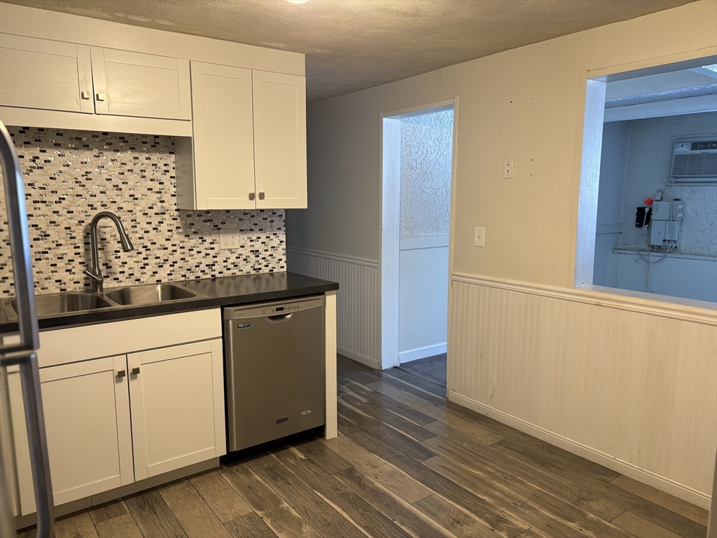 24 Spencer Road, Unit 12N Boxborough, MA 01719 - Photo 2 of 12 a kitchen with granite countertop white cabinets and wooden floor