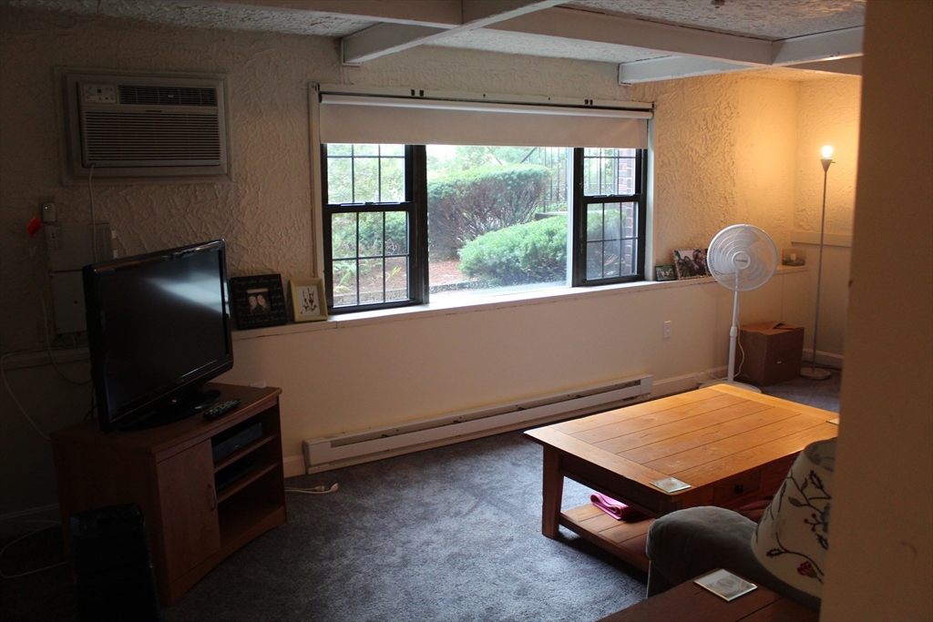 24 Spencer Road, Unit 12N Boxborough, MA 01719 - Photo 3 of 7 a room with furniture and a flat screen tv