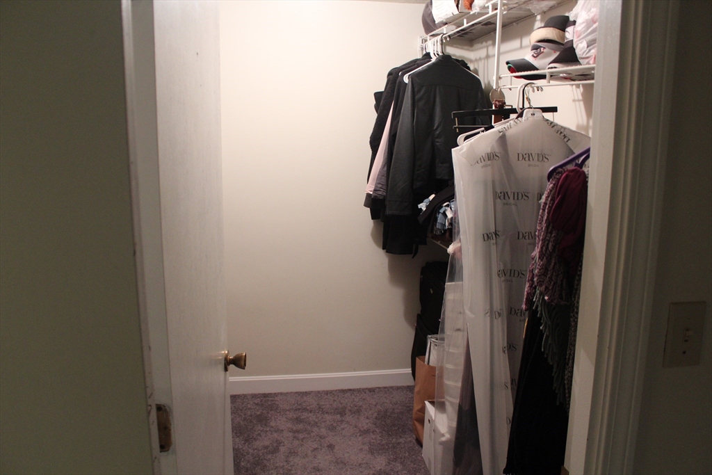 24 Spencer Road, Unit 12N Boxborough, MA 01719 - Photo 7 of 7 a view of walk in closet with clothes and shoes