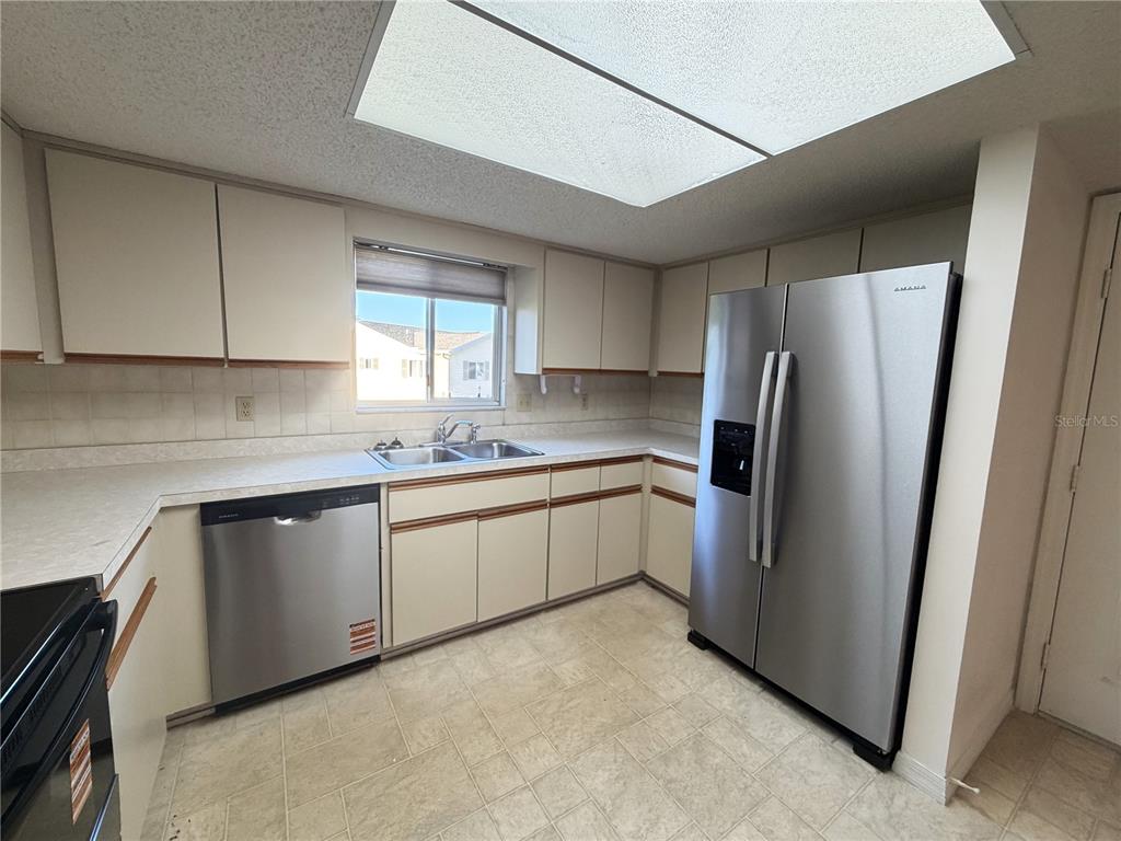 10980 Southwest 62nd Avenue Ocala, FL 34476 - Photo 13 of 48 a kitchen with stainless steel appliances a refrigerator sink and cabinets