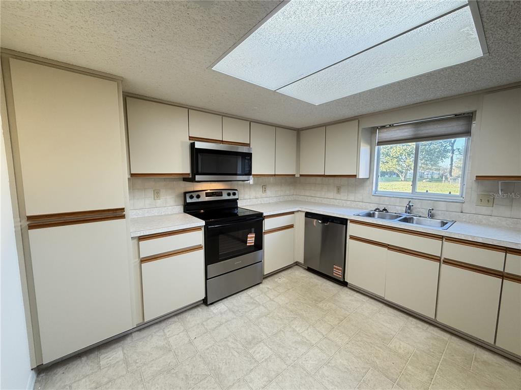 10980 Southwest 62nd Avenue Ocala, FL 34476 - Photo 15 of 48 a kitchen with a sink stainless steel appliances and cabinets