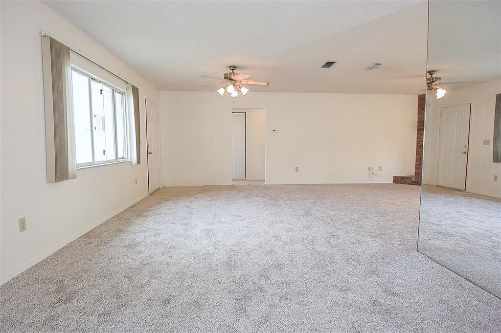10980 Southwest 62nd Avenue Ocala, FL 34476 - Photo 10 of 48 an empty room with chandelier fan and windows