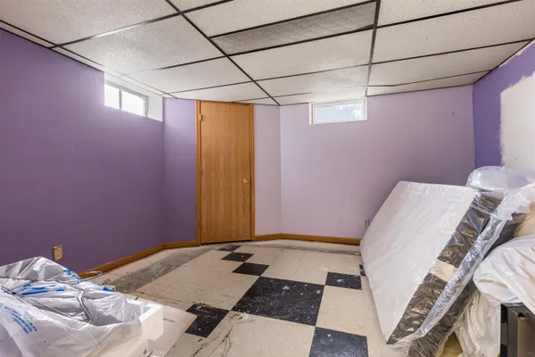 a bed sitting in a bedroom next to a window