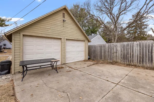 a backyard of a house with barbeque oven and wooden fence