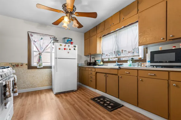 a kitchen with a refrigerator a stove a microwave cabinets and wooden floor