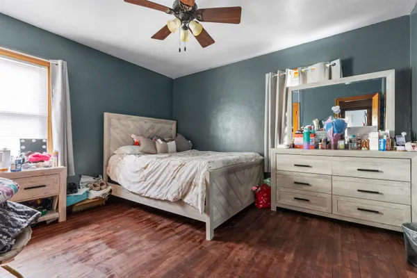 a bedroom with a bed and a mirror on dresser