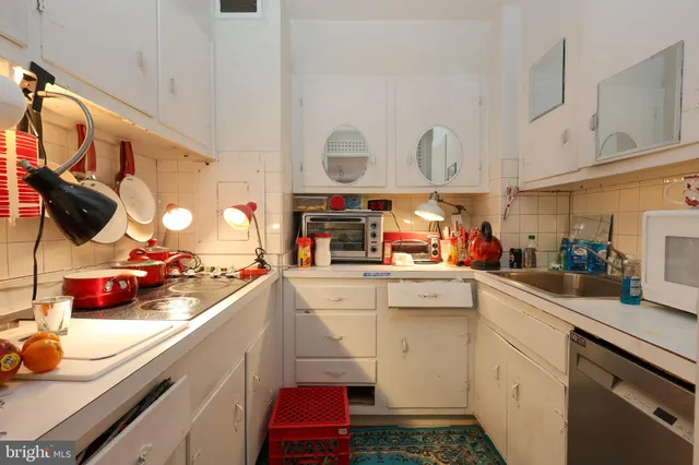 a kitchen with stainless steel appliances a sink a stove and white cabinets