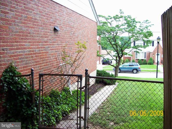 8208 Edwill Avenue Rosedale, MD 21237 - Photo 3 of 18 a view of a brick wall with plants and a bench