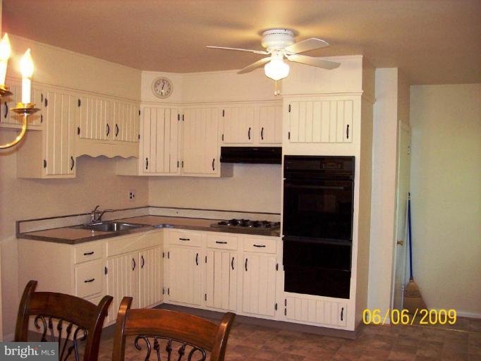 8208 Edwill Avenue Rosedale, MD 21237 - Photo 8 of 18 a kitchen with stainless steel appliances granite countertop a stove a sink and white cabinets