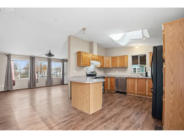 a kitchen with stainless steel appliances granite countertop a refrigerator and a stove