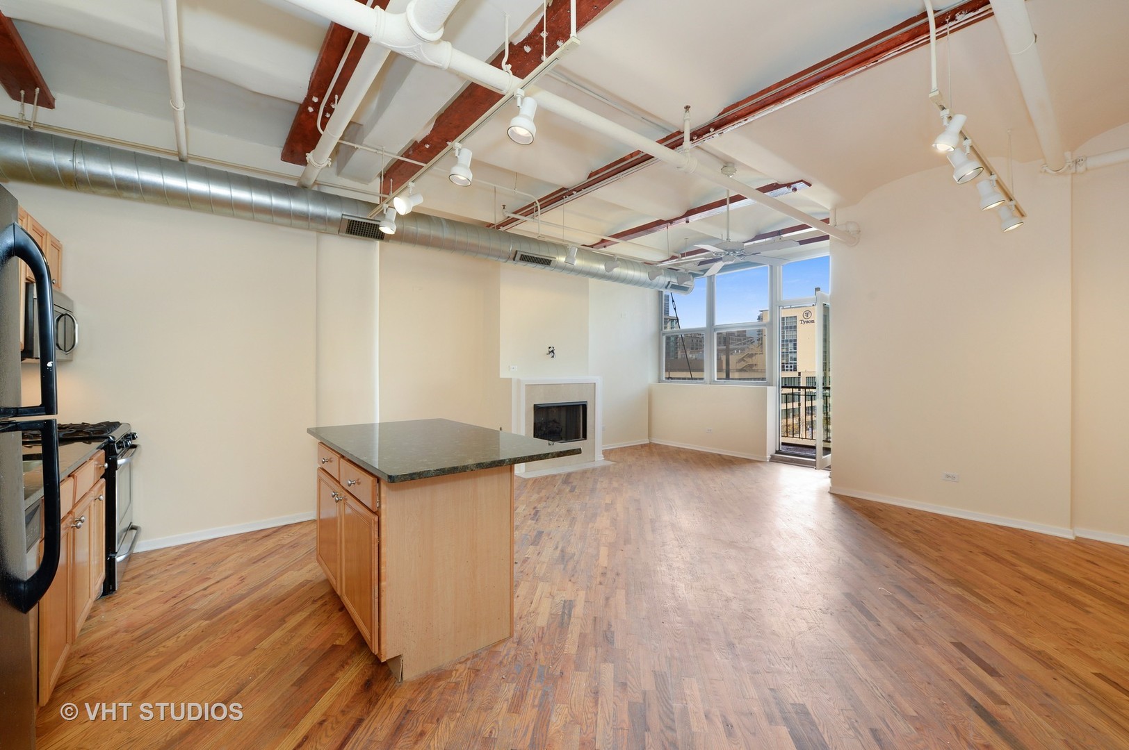 500 South Clinton Street, Unit 542 Chicago, IL 60607 - Photo 6 of 14 a kitchen with granite countertop a wooden floor and a stove