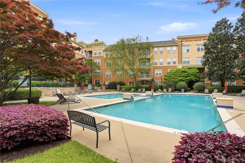 10 Perimeter Summit Boulevard, Unit 1204 Atlanta, GA 30319 - Photo 13 of 39 a view of a swimming pool and lounge chairs