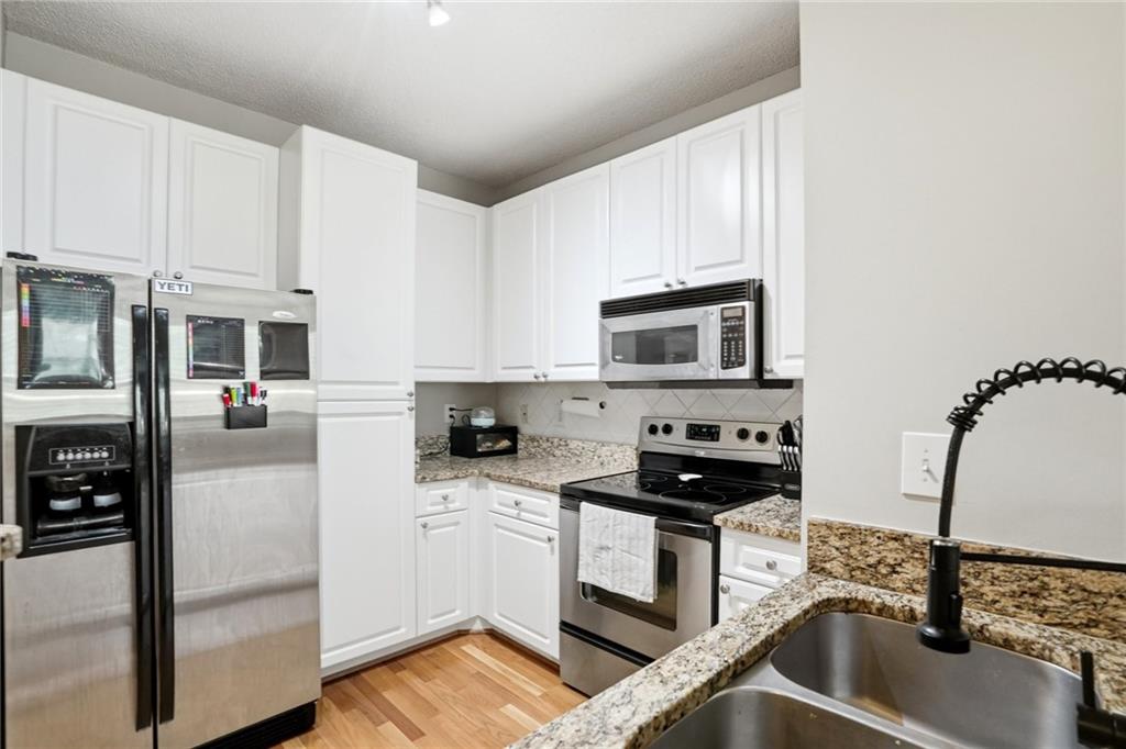 10 Perimeter Summit Boulevard, Unit 1204 Atlanta, GA 30319 - Photo 2 of 39 a kitchen with white cabinets and appliances