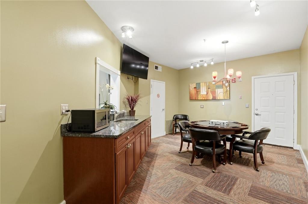10 Perimeter Summit Boulevard, Unit 1204 Atlanta, GA 30319 - Photo 26 of 39 a dining room with furniture and a chandelier