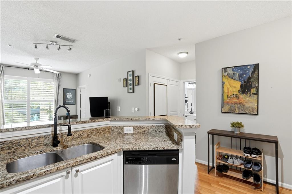 10 Perimeter Summit Boulevard, Unit 1204 Atlanta, GA 30319 - Photo 3 of 39 a kitchen with stainless steel appliances granite countertop a sink and a refrigerator