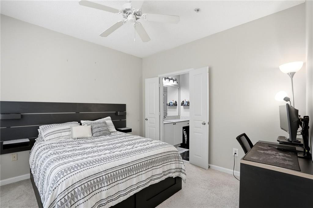 10 Perimeter Summit Boulevard, Unit 1204 Atlanta, GA 30319 - Photo 4 of 39 a bedroom with a bed and a flat tv screen on the dresser