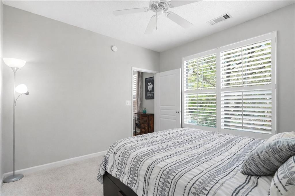 10 Perimeter Summit Boulevard, Unit 1204 Atlanta, GA 30319 - Photo 5 of 39 a bedroom with a bed and a chandelier