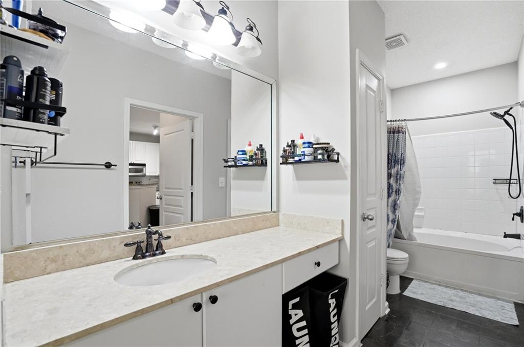 10 Perimeter Summit Boulevard, Unit 1204 Atlanta, GA 30319 - Photo 6 of 39 a bathroom with a double vanity sink a mirror and a shower