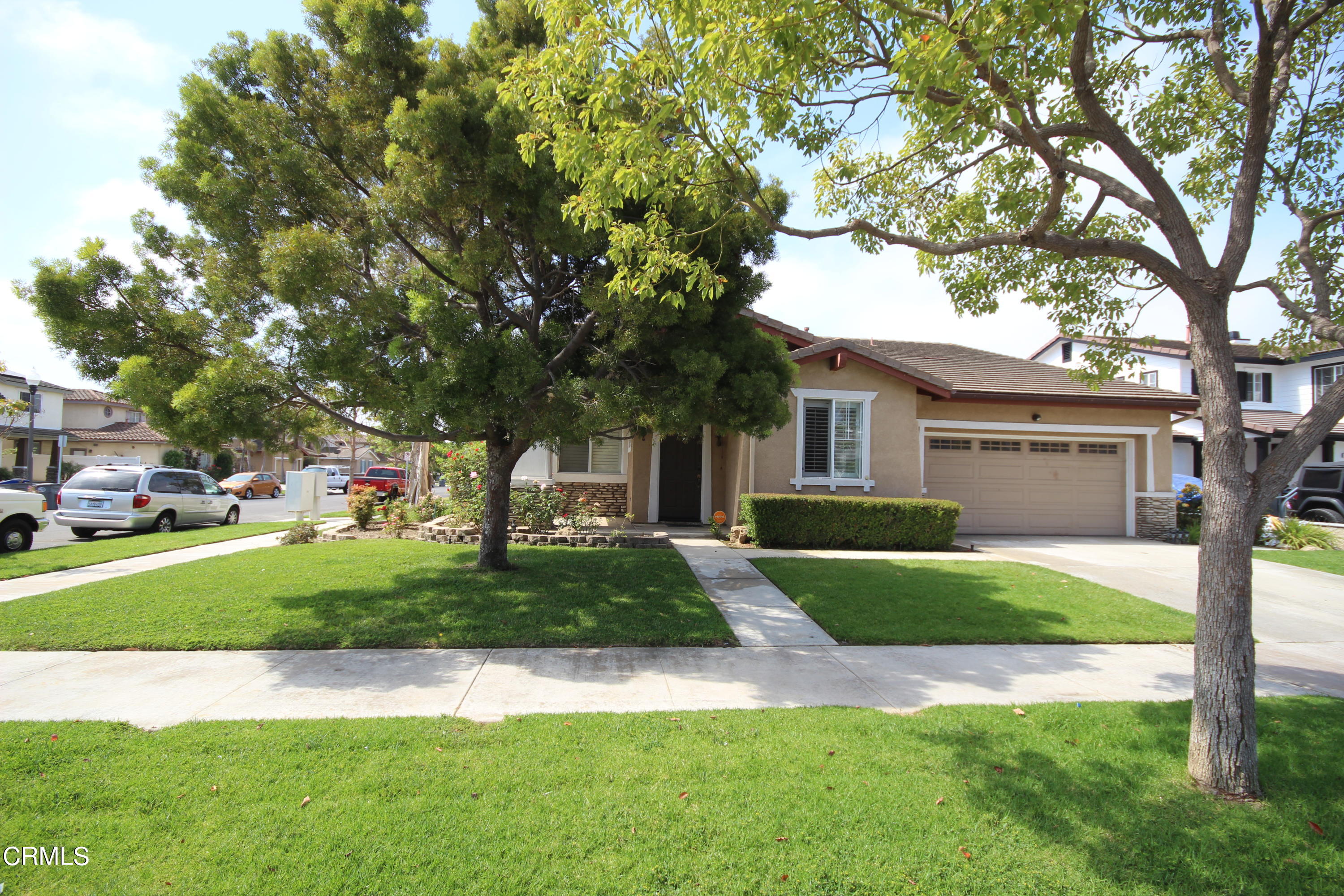 1034 Caliente Way Oxnard, CA 93036 - Photo 2 of 12 a front view of a house with a yard and trees