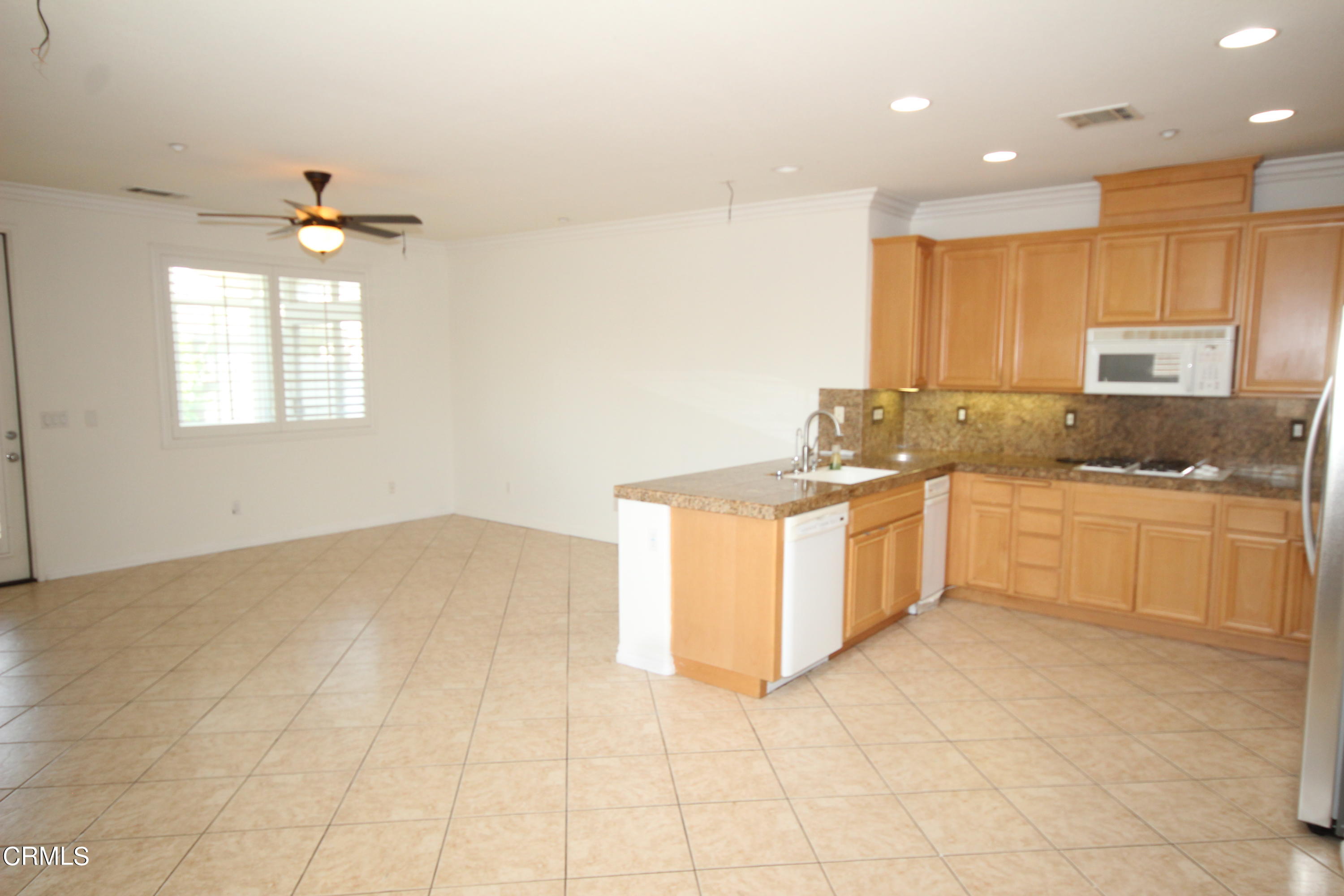 1034 Caliente Way Oxnard, CA 93036 - Photo 4 of 12 a kitchen with a stove a sink a window and white cabinets