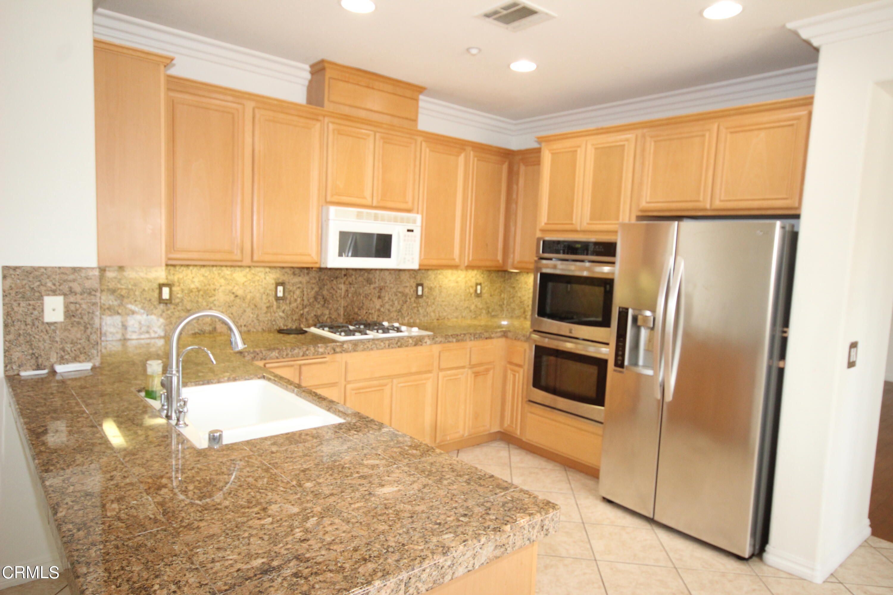 1034 Caliente Way Oxnard, CA 93036 - Photo 5 of 12 a kitchen with granite countertop a refrigerator and a sink