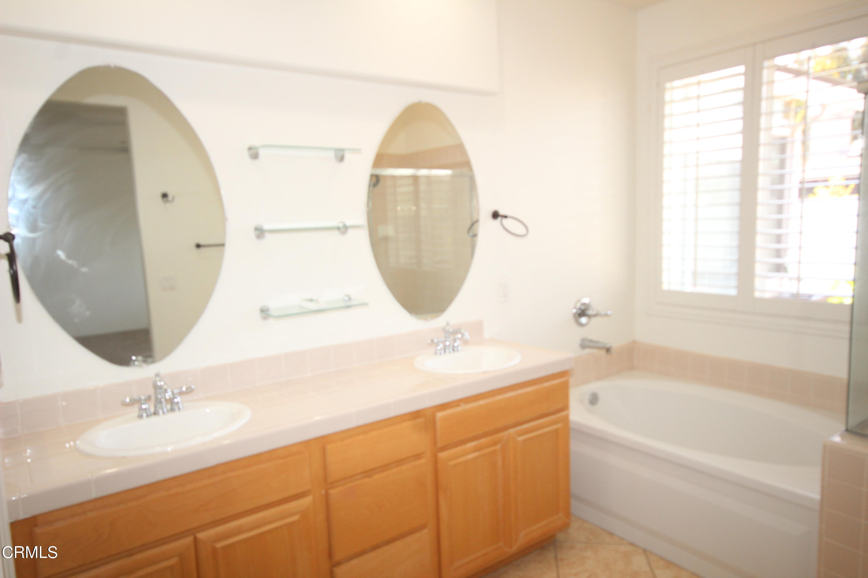 1034 Caliente Way Oxnard, CA 93036 - Photo 6 of 12 a bathroom with a sink and mirror with bathtub