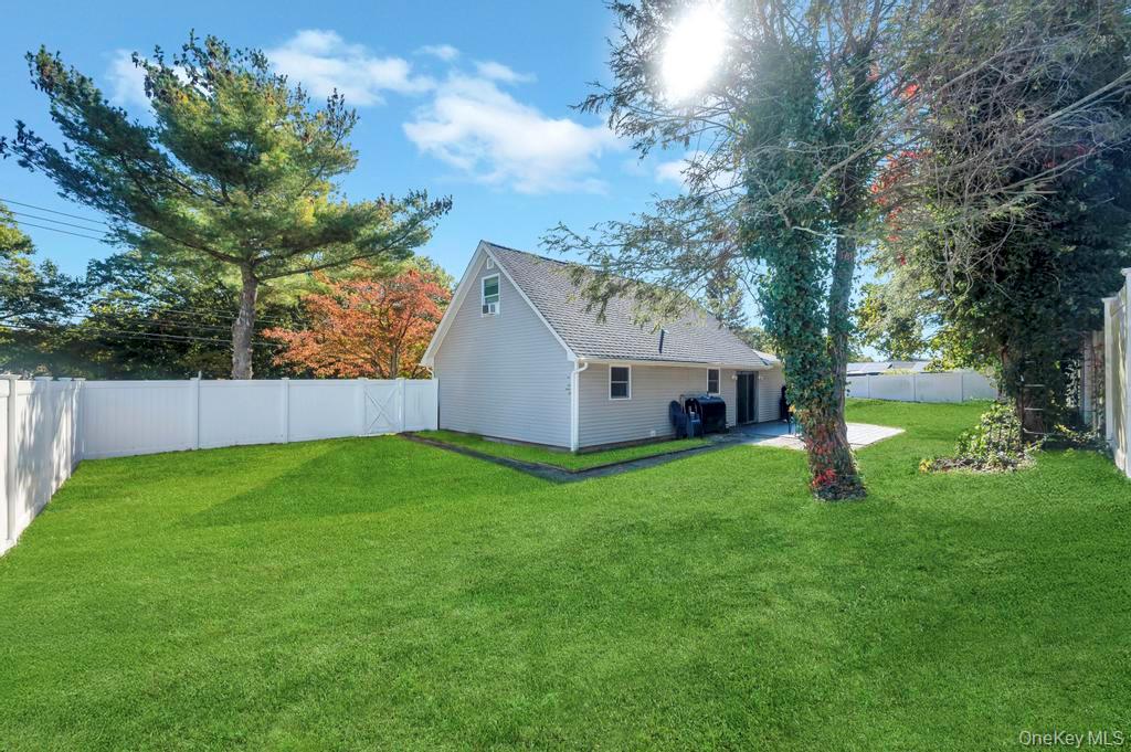 382 Boyle Road Selden, NY 11784 - Photo 9 of 26 a yellow house sitting in the grass