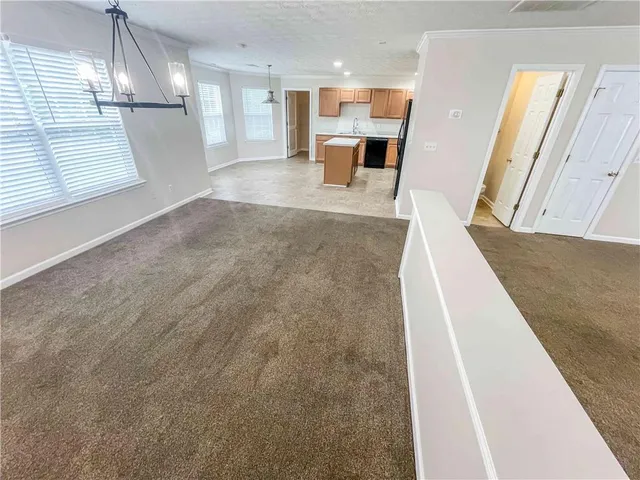 a view of kitchen with granite countertop sink and refrigerator