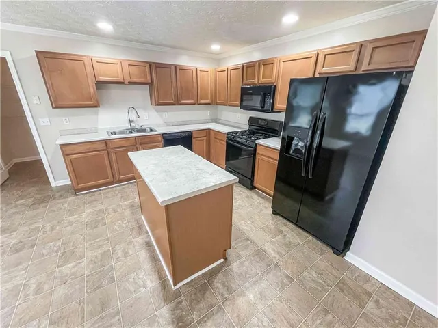a kitchen with stainless steel appliances a refrigerator sink and stove