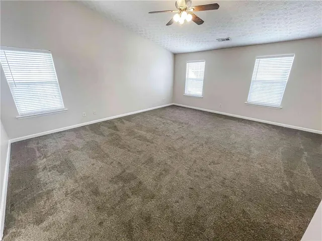 an empty room with chandelier fan