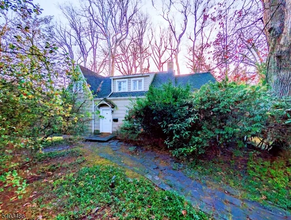 a view of a house with a tree and garden