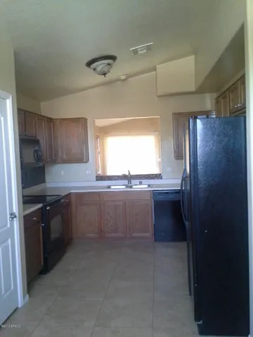 a kitchen with granite countertop a refrigerator and a sink