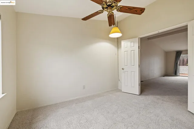 an empty room with a fan and a fan