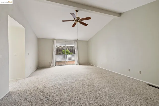 a view of a livingroom with a ceiling fan and window