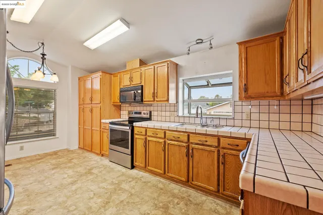 a spacious kitchen with stainless steel appliances granite countertop a sink and cabinets