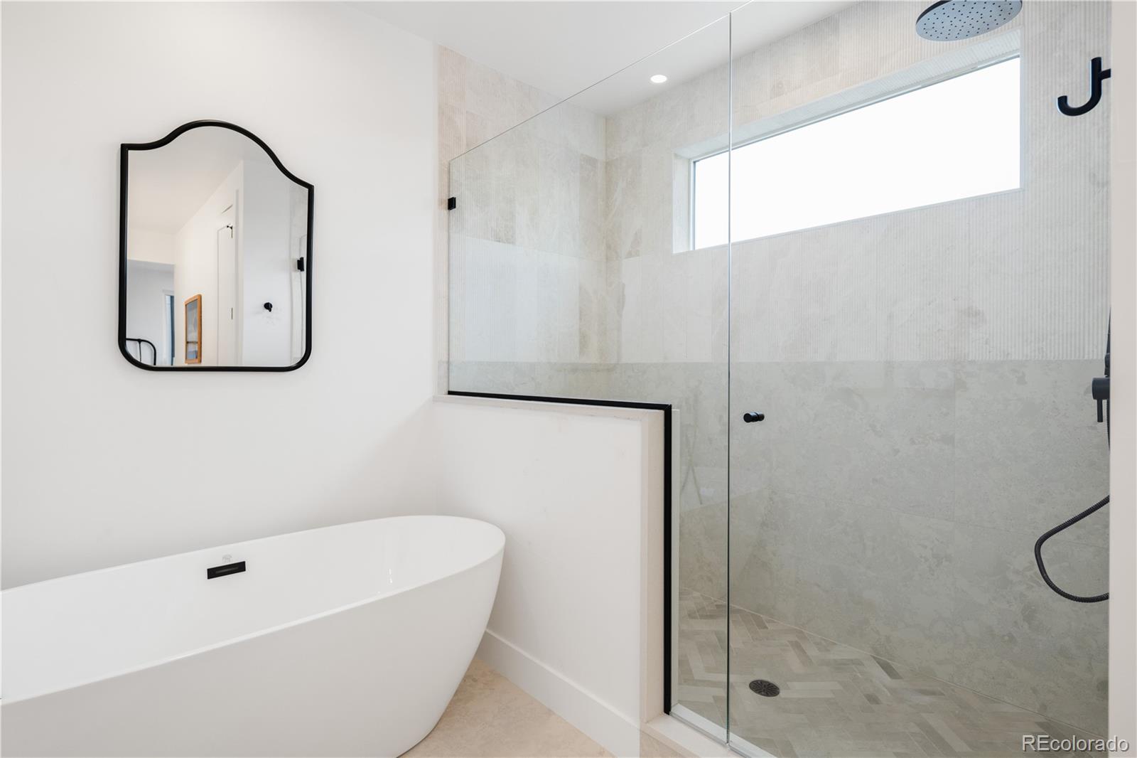 1205 Utica Street Denver, CO 80204 - Photo 24 of 35 a bathroom with a tub a window and a glass door shower