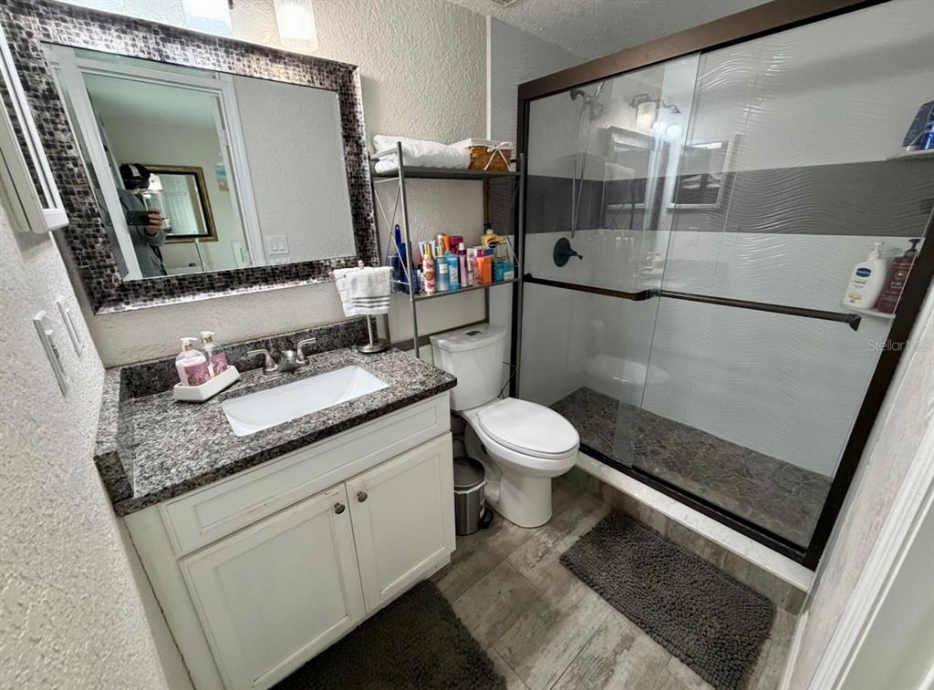 1938 South Conway Road, Unit 7 Orlando, FL 32812 - Photo 15 of 23 a bathroom with a granite countertop sink toilet and mirror