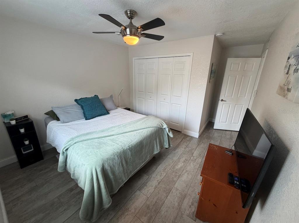 1938 South Conway Road, Unit 7 Orlando, FL 32812 - Photo 20 of 23 a bedroom with a bed and a flat tv screen on a dresser