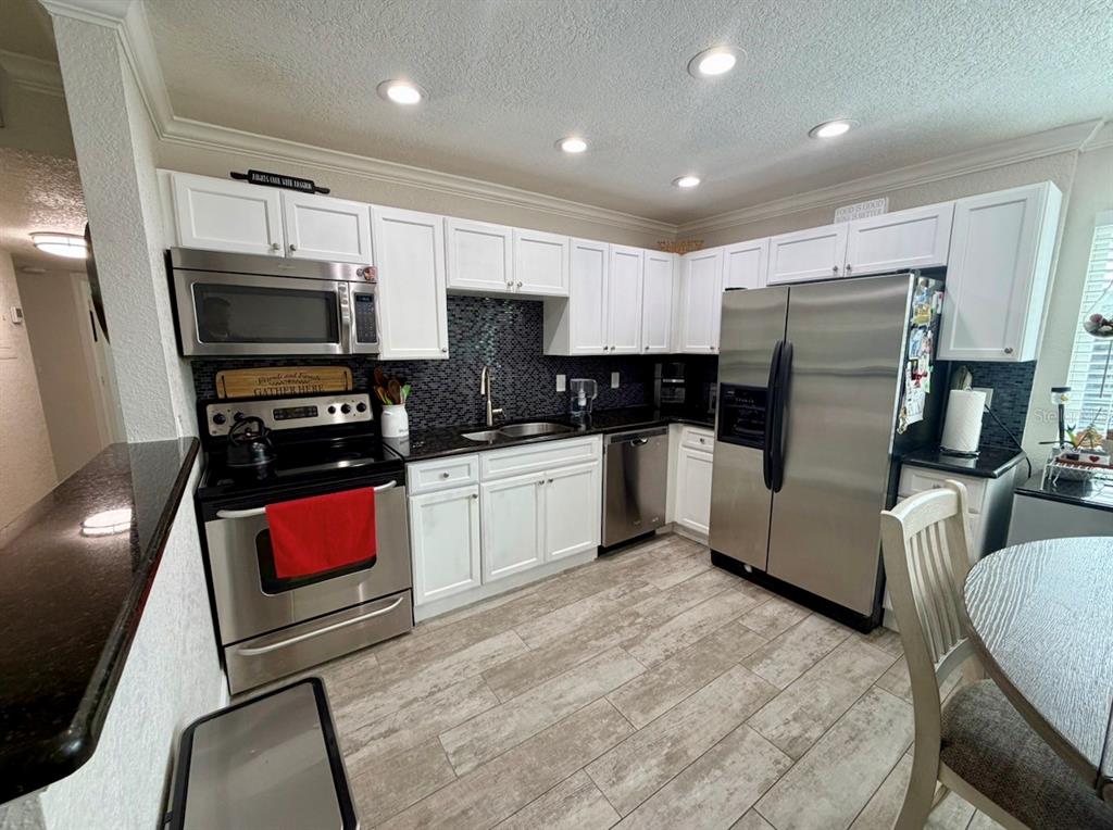 1938 South Conway Road, Unit 7 Orlando, FL 32812 - Photo 6 of 23 a kitchen with stainless steel appliances a refrigerator sink and microwave