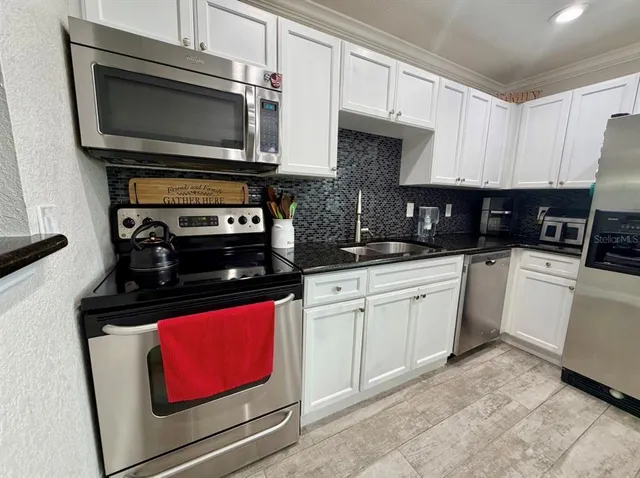 a kitchen with granite countertop a stove and a microwave