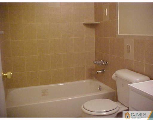 87 Pheasant Run Edison, NJ 08820 - Photo 3 of 7 a bath tub sitting next to a white toilet and a shower